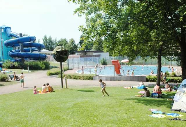 Liegewiese mit Blick auf Kinderplanschbereich und Lehrschwimmbecken