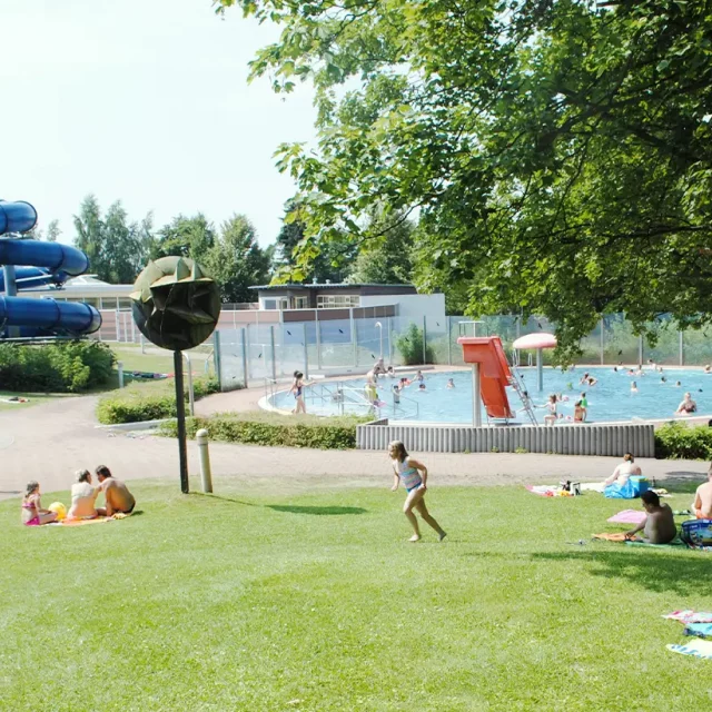 Liegewiese mit Blick auf Kinderplanschbereich und Lehrschwimmbecken